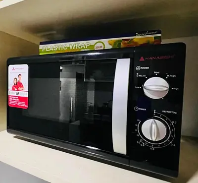 a black microwave with a box on a shelf at D'Gonia Space in Manila