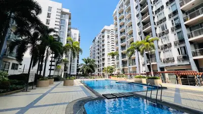 a swimming pool with palm trees and buildings at D'Gonia Space in Manila