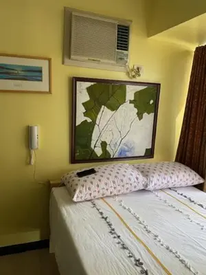 a bedroom with a bed and a picture on the wall at South of Market Private Risidence in Manila