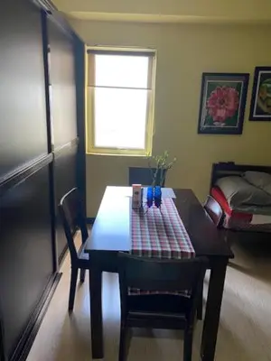 a room with a table and chairs and a bed at South of Market Private Risidence in Manila