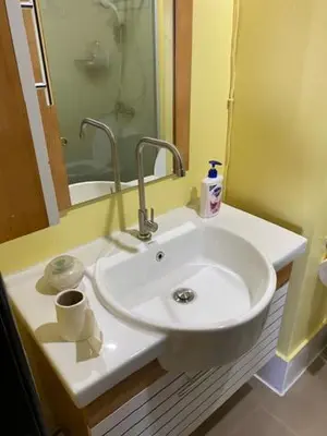a bathroom with a white sink and a mirror at South of Market Private Risidence in Manila