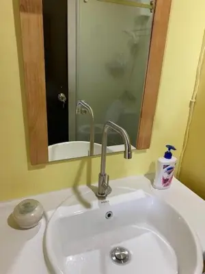 a white bathroom sink with a mirror and a sink at South of Market Private Risidence in Manila