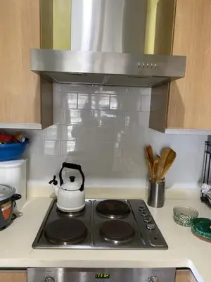 a stove top with a tea kettle on top of it at South of Market Private Risidence in Manila