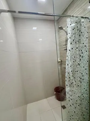 a shower with a glass curtain in a bathroom at Cozy Studio at Venice Grand Canal Near BGC & NAIA in Manila
