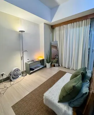 a living room with a large window and a couch at Cozy Studio at Venice Grand Canal Near BGC & NAIA in Manila