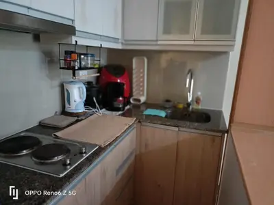 a small kitchen with a stove and a sink at Cozy Studio at Venice Grand Canal Near BGC & NAIA in Manila