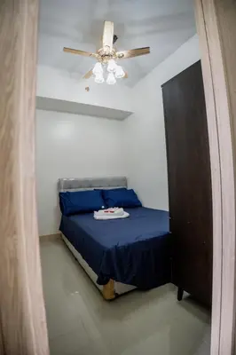 a bedroom with a blue bed with a ceiling fan at R and K staycation in Manila