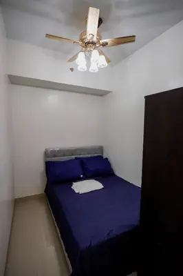 a bedroom with a ceiling fan and a blue bed at R and K staycation in Manila