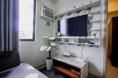 a living room with a tv and a table at R and K staycation in Manila