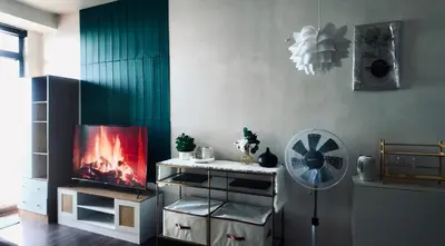 a living room with a tv and a fan at Reset at the Gramercy in Manila