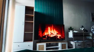 a fireplace in a living room with a fire in it at Reset at the Gramercy in Manila