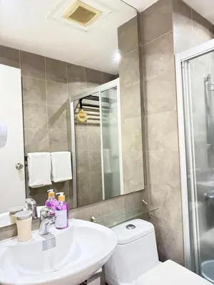 a bathroom with a sink and a toilet and a mirror at Reset at the Gramercy in Manila