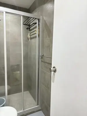 a shower with a glass door in a bathroom at Reset at the Gramercy in Manila