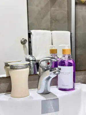 a bathroom sink with two bottles of soap and a faucet at Reset at the Gramercy in Manila