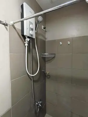 a shower with a microphone in a bathroom at Staycation by Carlo and Chel's in Manila