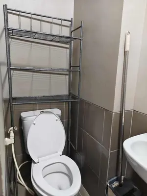 a bathroom with a toilet and a sink at Staycation by Carlo and Chel's in Manila