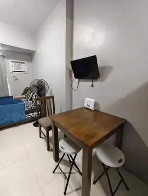 a living room with a wooden table and chairs at Staycation by Carlo and Chel's in Manila