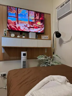 a bedroom with a flat screen tv on a wall at Cozy Staycation in Cubao with Netflix in Manila