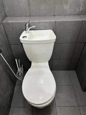 a bathroom with a white toilet and a sink at Cozy Staycation in Cubao with Netflix in Manila