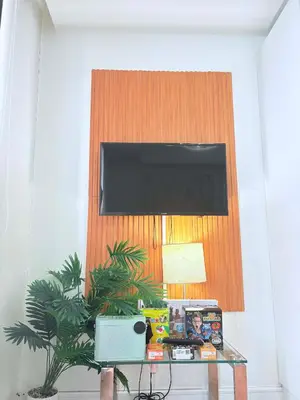 a room with a table with a television on a wall at 1 bedroom at Azure Urban Resort Condo in Manila