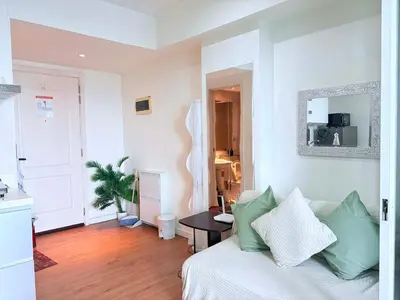 a living room with a white couch and a table at 1 bedroom at Azure Urban Resort Condo in Manila
