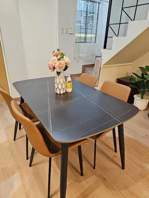 a black dining room table with chairs and a vase of flowers at Cozy Bian Getaway - Entire House for Rent in Biñan