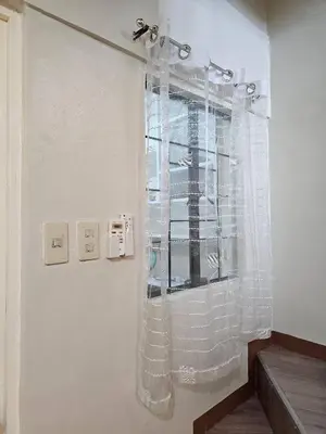 a shower with a glass curtain in a bathroom at Cozy Bian Getaway - Entire House for Rent in Biñan