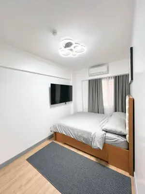a bedroom with a bed and a flat screen tv at Raya and Zane in Manila