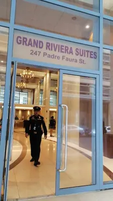 a police officer walking out of a grand riviera suites pacific at Cozy Condo Near US Embassy in Manila in Manila