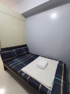 a small room with a bed with blue and white at Sea Residences Near MOA SMX Pasay City in Manila