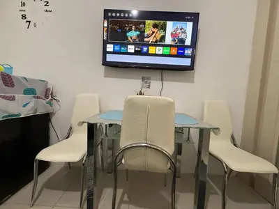 a table and chairs with a tv on a wall at Sea Residences Near MOA SMX Pasay City in Manila
