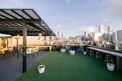 a rooftop patio with green grass and tables and chairs at Canopy Agutaya BGC in Manila