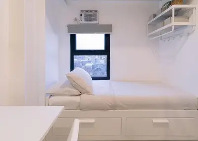 a white room with a bed and a window at Canopy Agutaya BGC in Manila