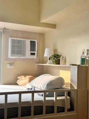 a bed in a room with a window and a pillow at Condotels by Irene in Manila