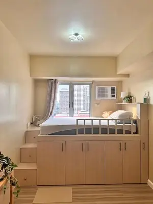 a bedroom with a large bed with a window at Condotels by Irene in Manila