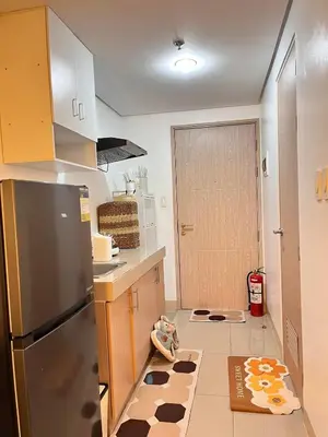 a kitchen with a stainless steel refrigerator and a dog rug at Sweetluxx - SMDC Green 2 Residences Staycation in Dasmariñas