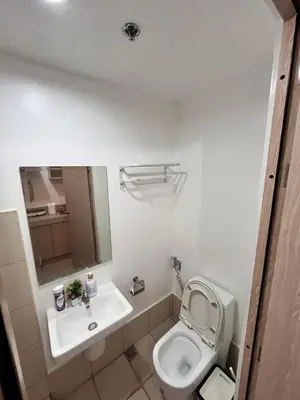 a white bathroom with a toilet and a sink at Sweetluxx - SMDC Green 2 Residences Staycation in Dasmariñas