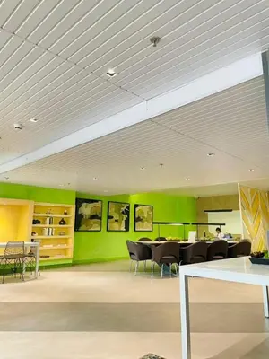 a room with tables and chairs and a green wall at Sweetluxx - SMDC Green 2 Residences Staycation in Dasmariñas
