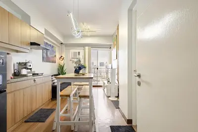 a kitchen with a small island in the middle at Stylish Condo - Cozy Urban Living in Manila