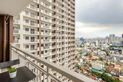 a balcony with a view of a city at Stylish Condo - Cozy Urban Living in Manila
