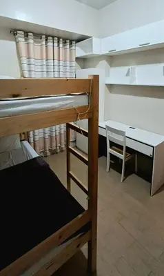 a dorm room with a bunk bed and a desk at Cozy Modern 2 Bedroom 81 Newport Boulevard in Manila