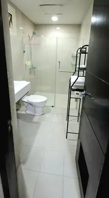 a bathroom with a toilet and a shower and a sink at Cozy Modern 2 Bedroom 81 Newport Boulevard in Manila