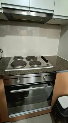 a stove top oven in a small kitchen at Cozy Modern 2 Bedroom 81 Newport Boulevard in Manila