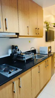 a kitchen with a sink and a counter top at Josh place Shell residence MOA in Manila