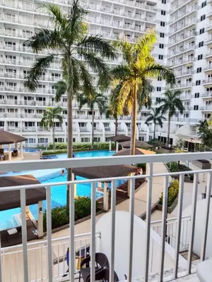 a view of the pool from the balcony of a apartment at Josh place Shell residence MOA in Manila