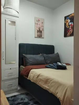a bed with a blue headboard in a bedroom at Wowstaycation in Manila