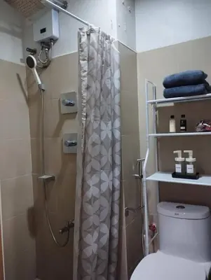 a bathroom with a shower curtain and a toilet at Wowstaycation in Manila
