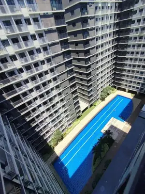 a large building with a swimming pool in front of it at Wowstaycation in Manila