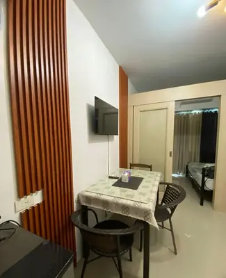 a room with a table and chairs and a television at Moa Staycaion Stern Homes in Manila
