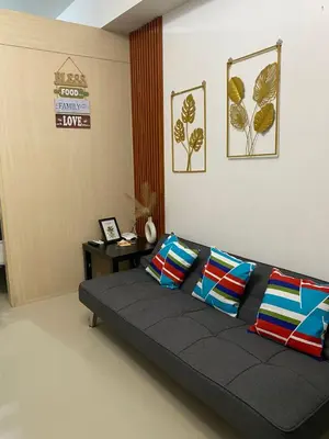 a black couch with pillows in a room at Moa Staycaion Stern Homes in Manila